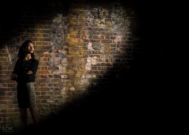 model in the spotlight with brick background